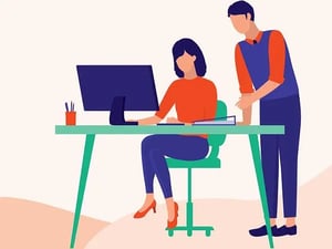 manager standing over person on computer