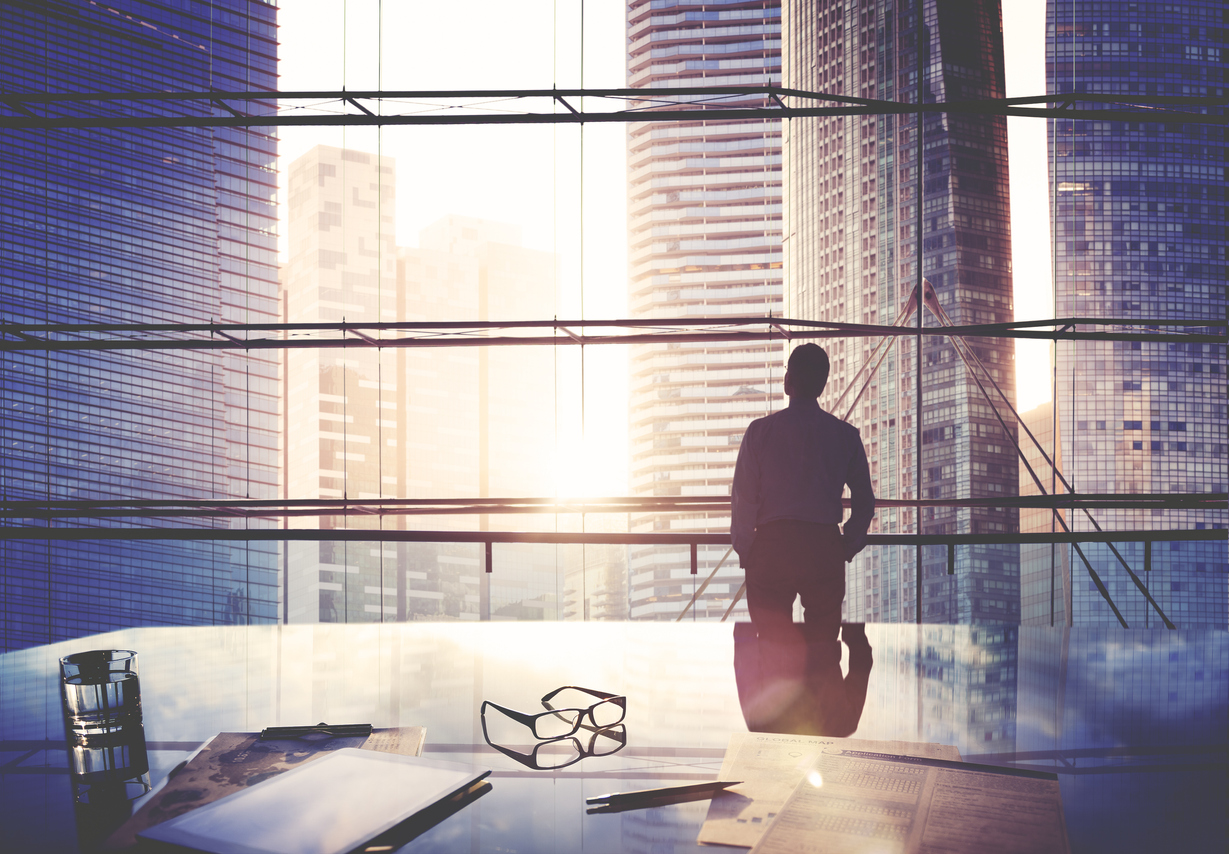 CEO in office looking out window of office to skyline